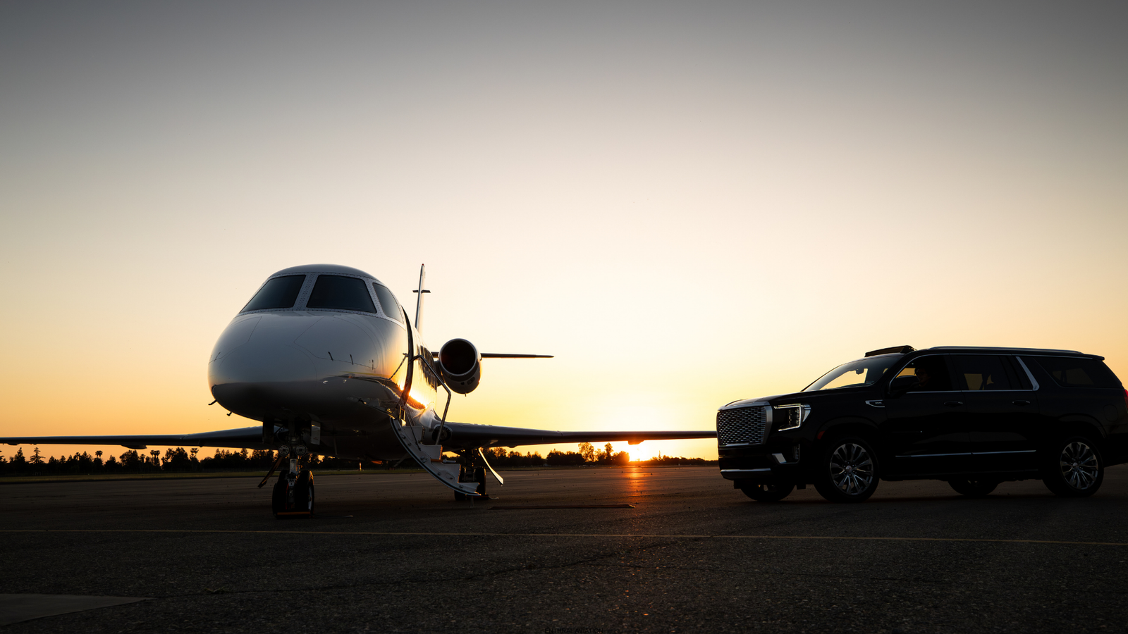 Chauffeur car beside a private jet on the tarmac